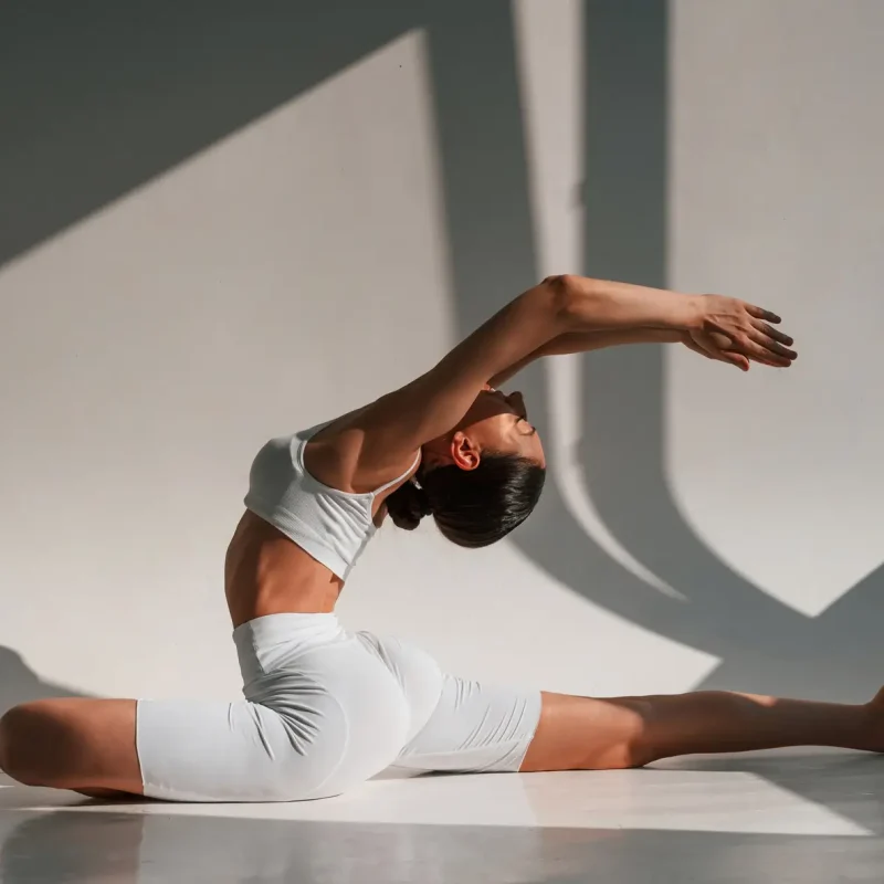 Donna in abbigliamento sportivo che esegue esercizi per la colonna vertebrale durante una sessione presso Attimo Pilates Milano