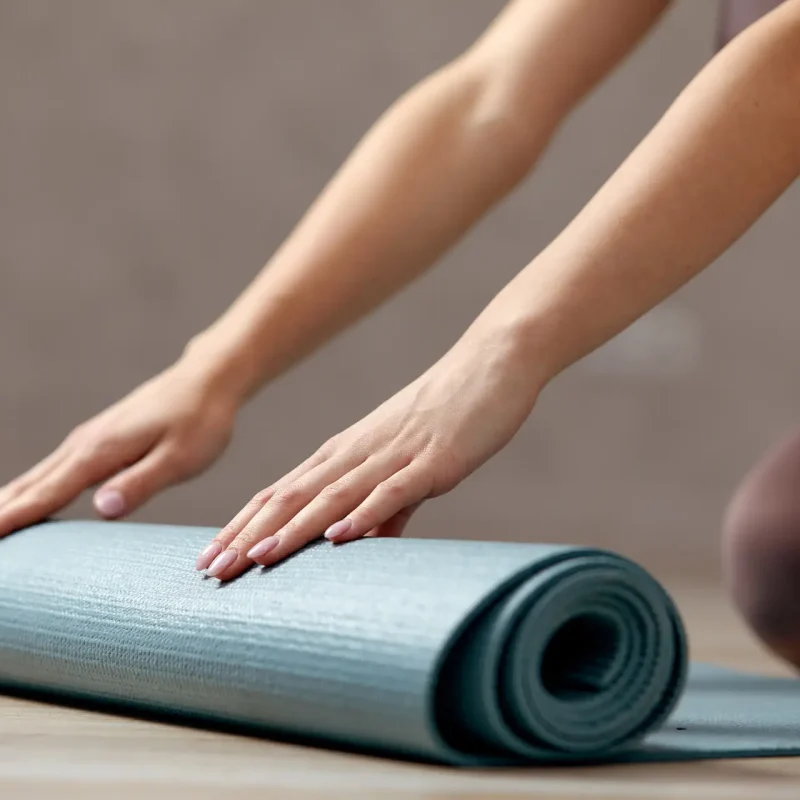 Donna che stende un tappetino per allenarsi presso Attimo Pilates Milano